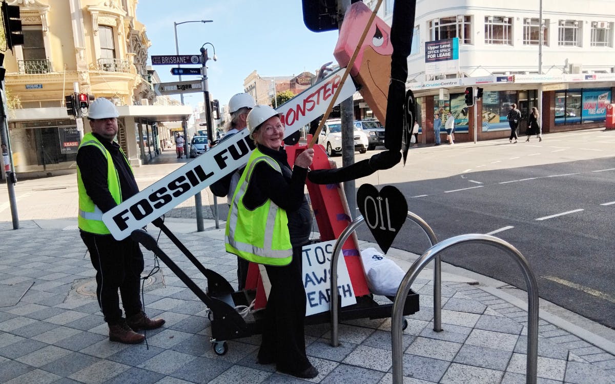 protesters with a fossil fuel monster in a Launceston street