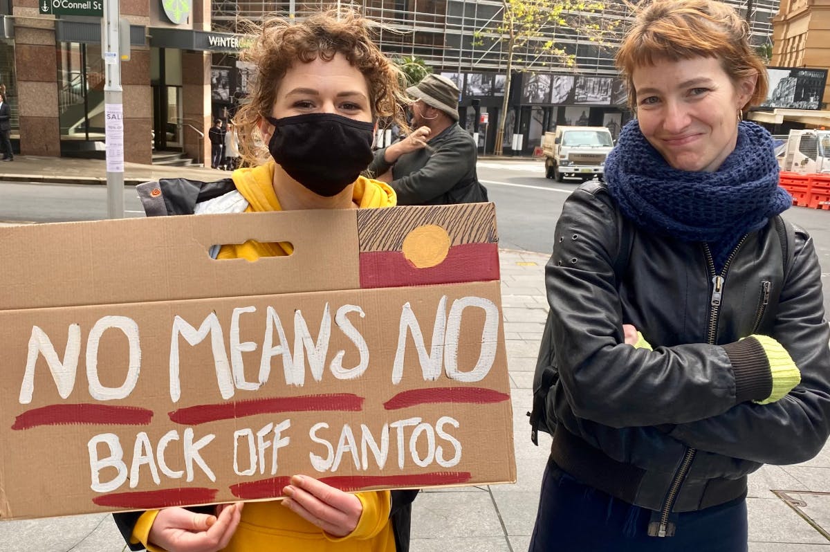 Activists holding a sign at Santos' Sydney office