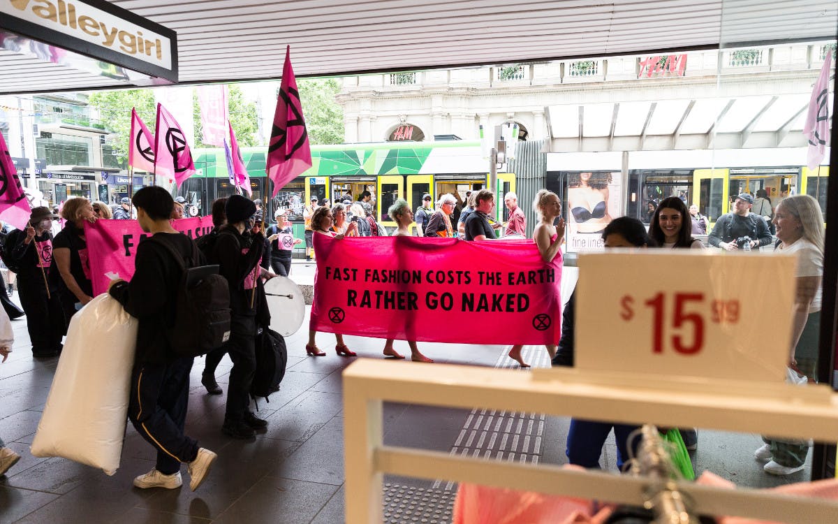 XR activists parade through Bourke Street mall with a banner